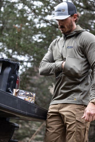 male wearing the Helio Hoody standing next to a truck tailgate with Federal Premium ammunition boxes
