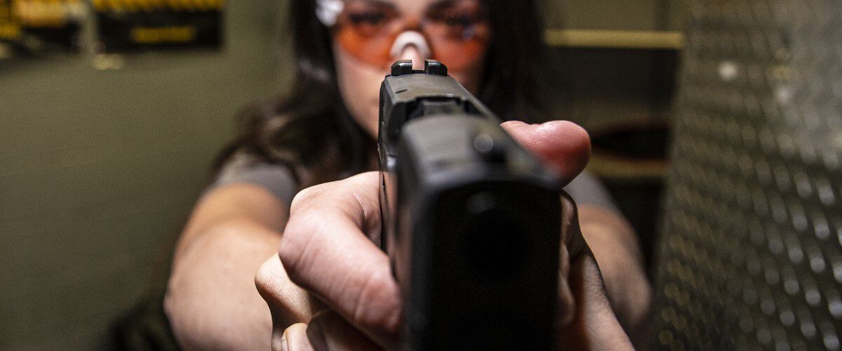 Woman pointing a handgun at the camera