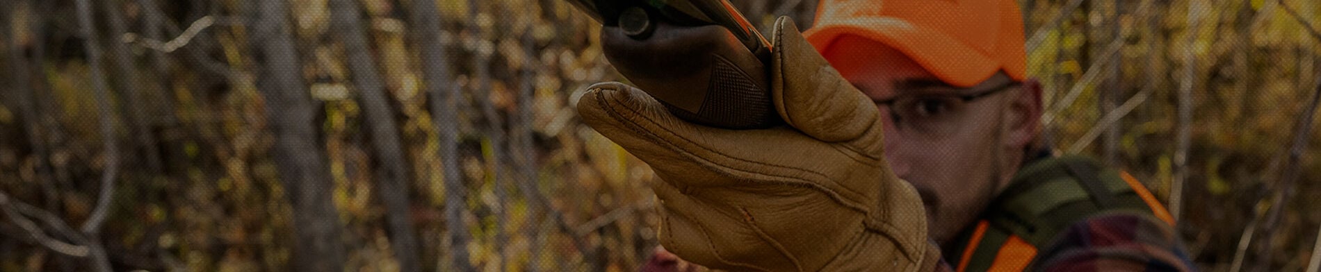 looking down the barrel at a man holding a shotgun