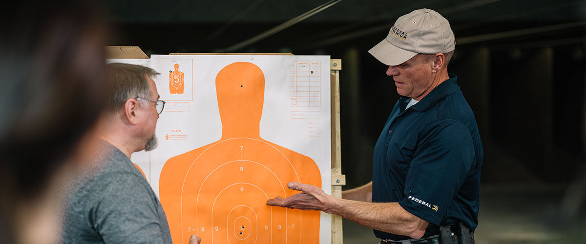 A person talking to others at an indoor gunrange