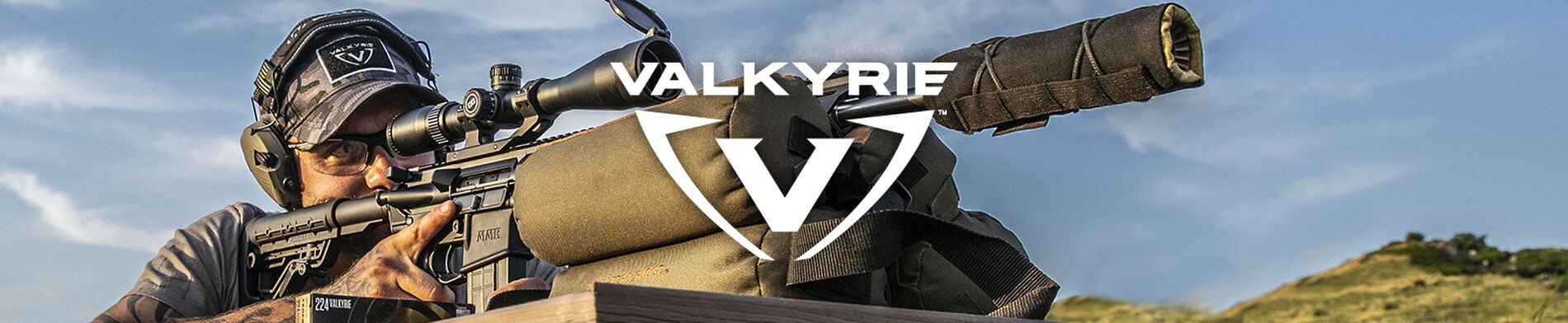 hunter looking down the scope of an AR on a bench rest with 224 Valkyrie Logo