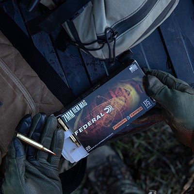 hunter holding Fusion Tipped Rifle box and cartridge