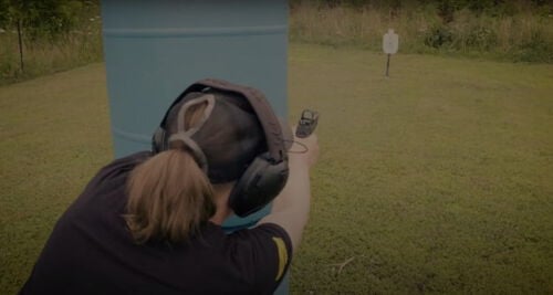 Julie Golob shooting around a barrier outside
