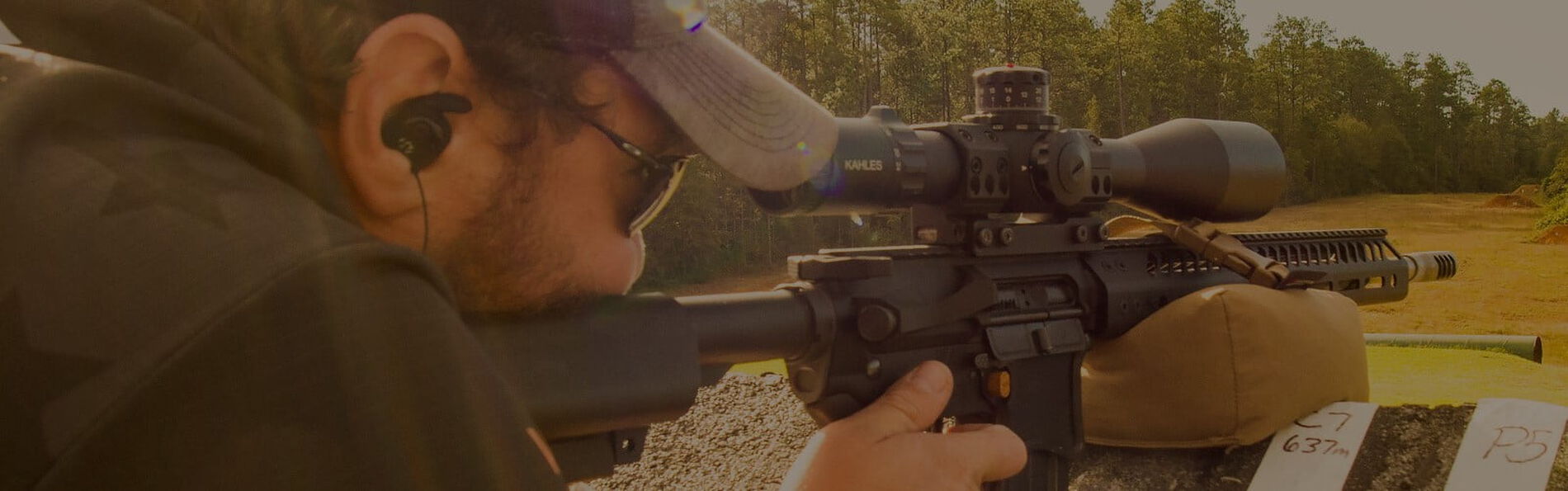 Jim Gilliland looking down the scope of a rifle