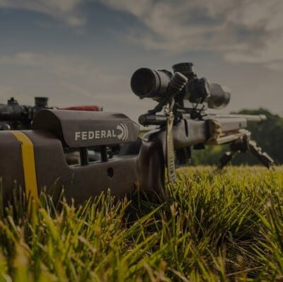 a long-range rifle on a bi-pod sitting in the grass