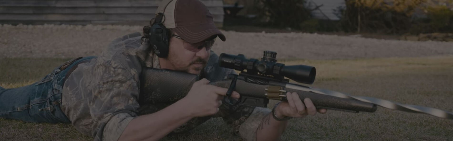 Jim Gilliland laying on the ground holding a rifle