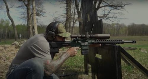 Josh Froelich shooting a rifle at an outdoor range