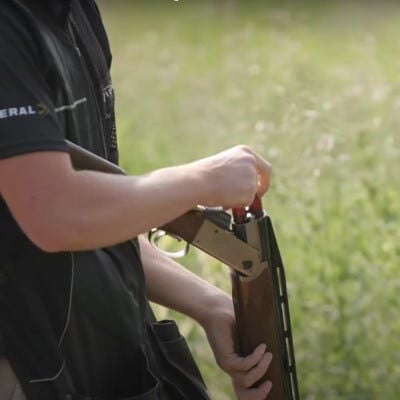 shooter adding shotshells to a shotgun