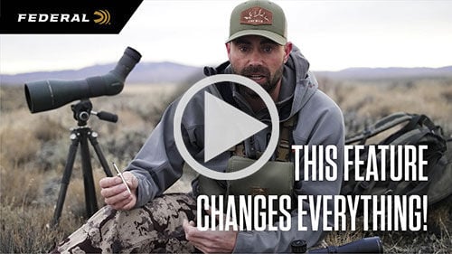 This Feature Changes Everything!; Remi Warren sitting next to scope on a tripod and holding 7mm backcountry cartridge