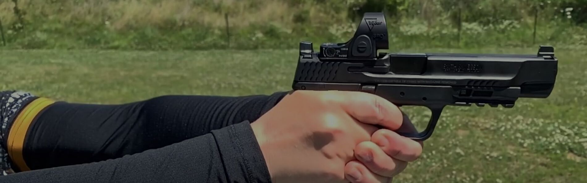 Julie Golob holding a pistol with red dot sights