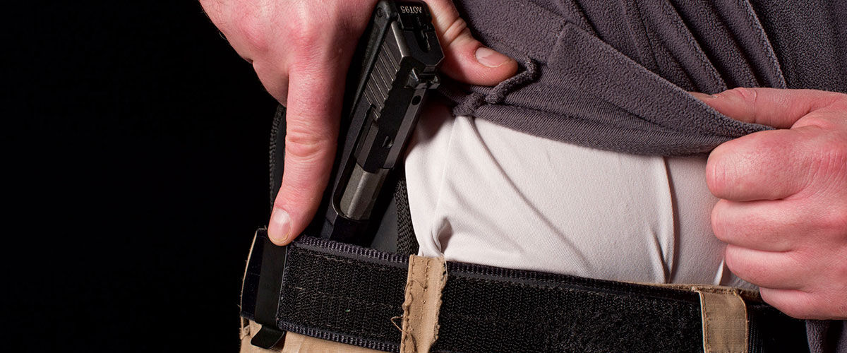 Person putting pistol in concealed holster