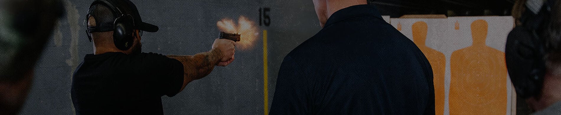 guy shooting a handgun at an indoor range