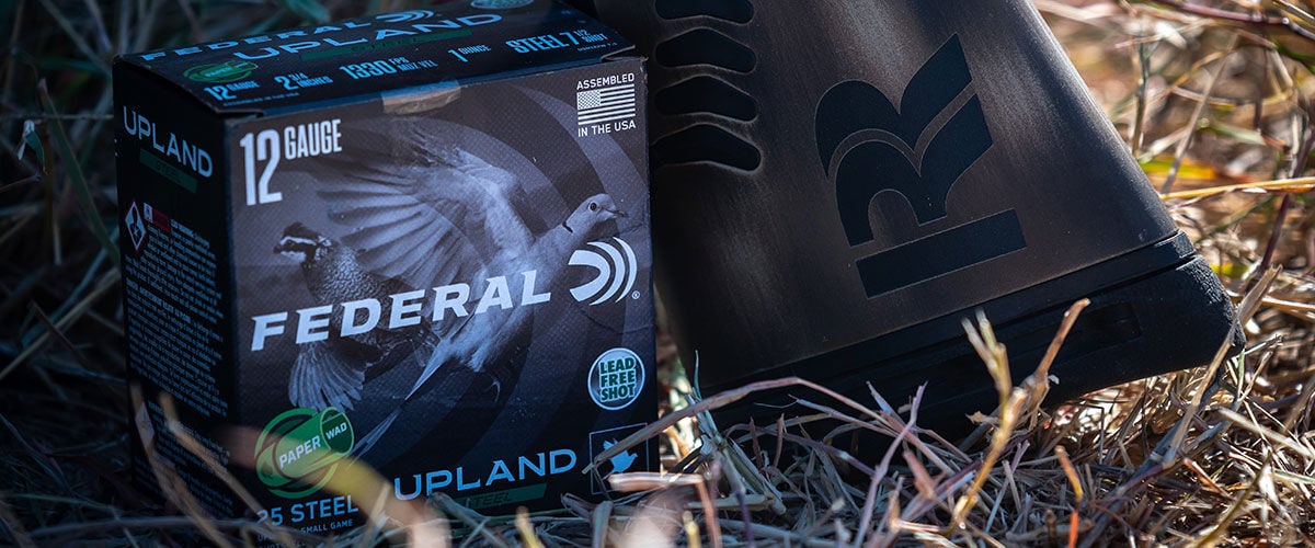 Federal Upland Steel Paper Wad box next to shotgun in the grass