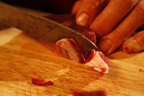 deer tenderloin being trimmed of fat and connective tissue