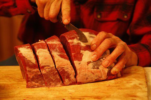 slicing the deer hind quarter meat into steaks