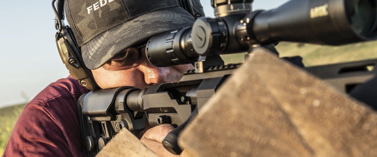 man looking down the scope of a rifle