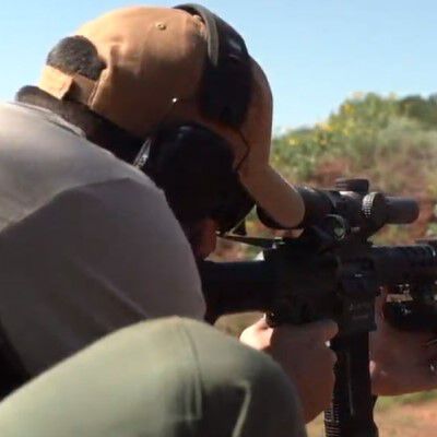 Hunter looking through binoculars on the prairie