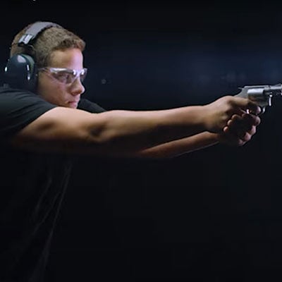 person aiming revolver