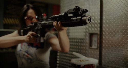 Krystal Dunn looking down an AR Scope at an indoor range