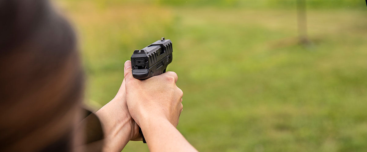 Person shooting handgun at an outdoor range
