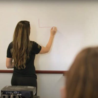 Ava standing in front of a white board