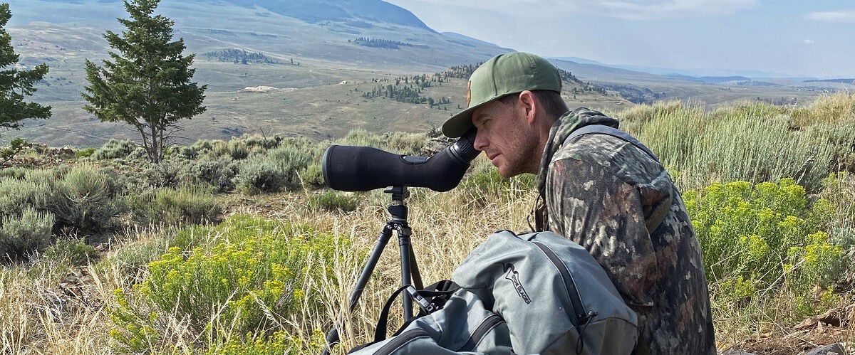 hunter looking through a spotting scope