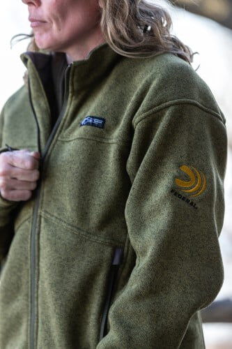 female wearing Zenith Jacket while holding the front zip