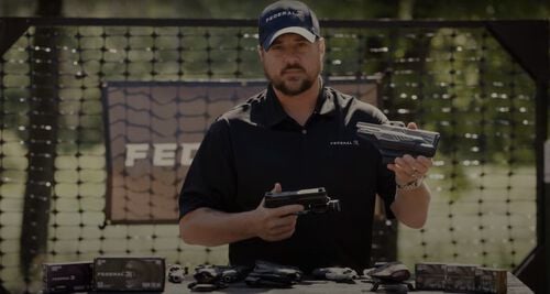 Jim Gilliland holding a pistol holster outside