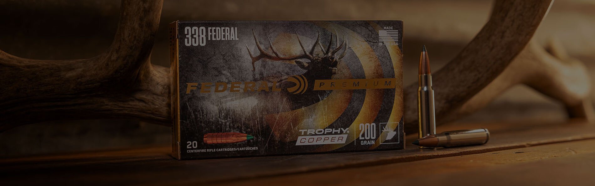 Federal Trophy Copper 338 Federal box on a table with an antler and cartridges