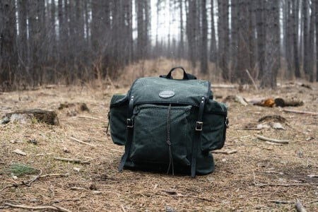 Rambler bag sitting on the ground in a wooded area