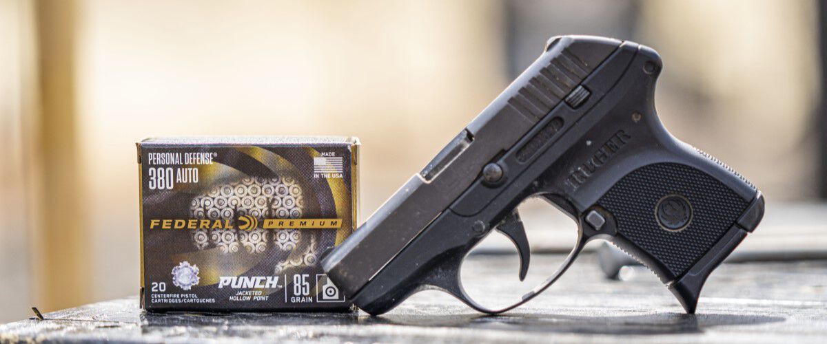 Handgun on a table with a box of Federal Premium Punch