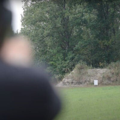 Josh Froelich aiming a pistol at a far away target