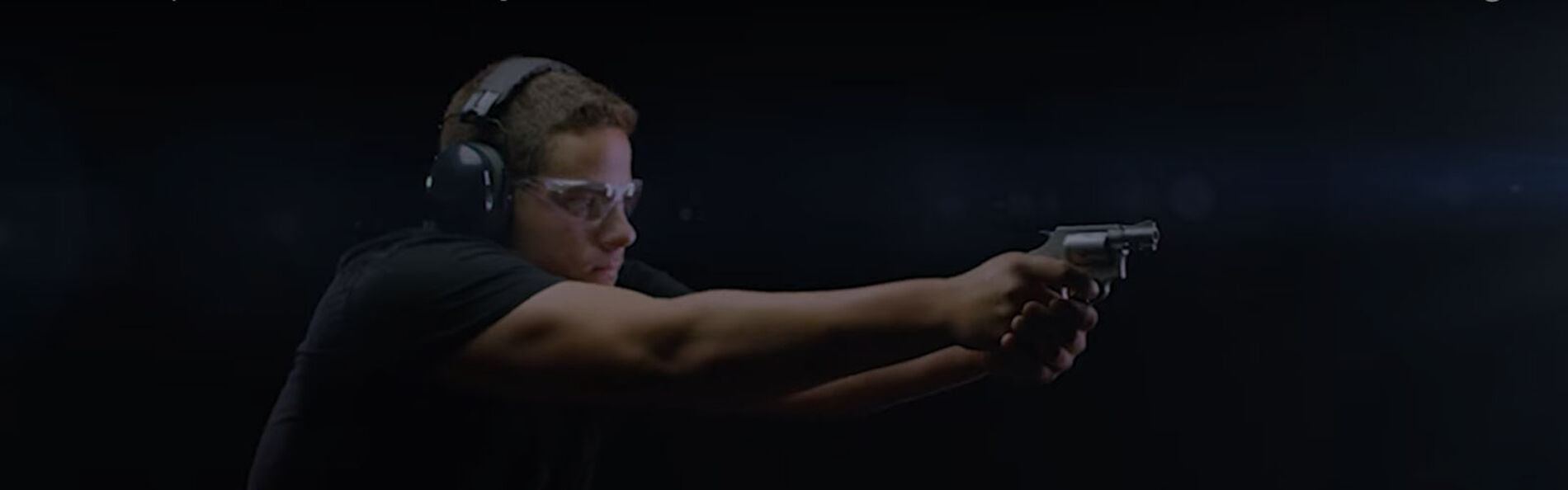 person aiming revolver