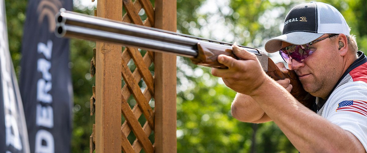 Derrik Mein aiming a shotgun