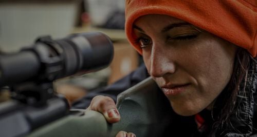 women looking down a rifle scope