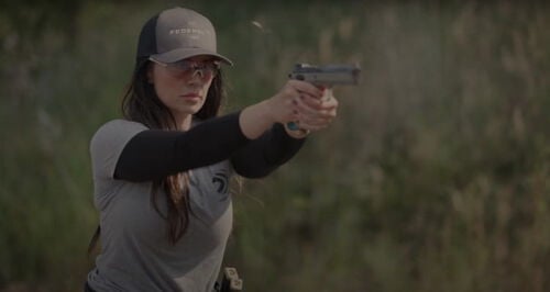 Krystal Dunn shooting a pistol outside