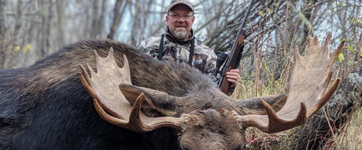 Hunter in front of a downed moose