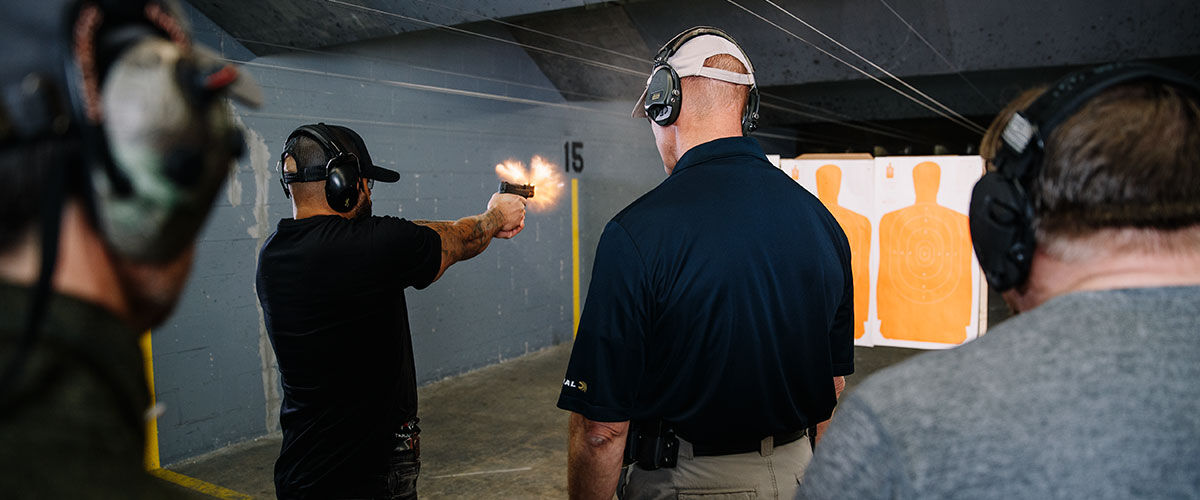 people at an indoor gun range training