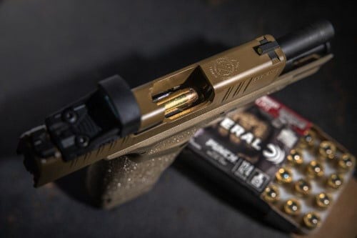 Punch Hellcat packaging and cartridges in front of a Springfield Armory Hellcat