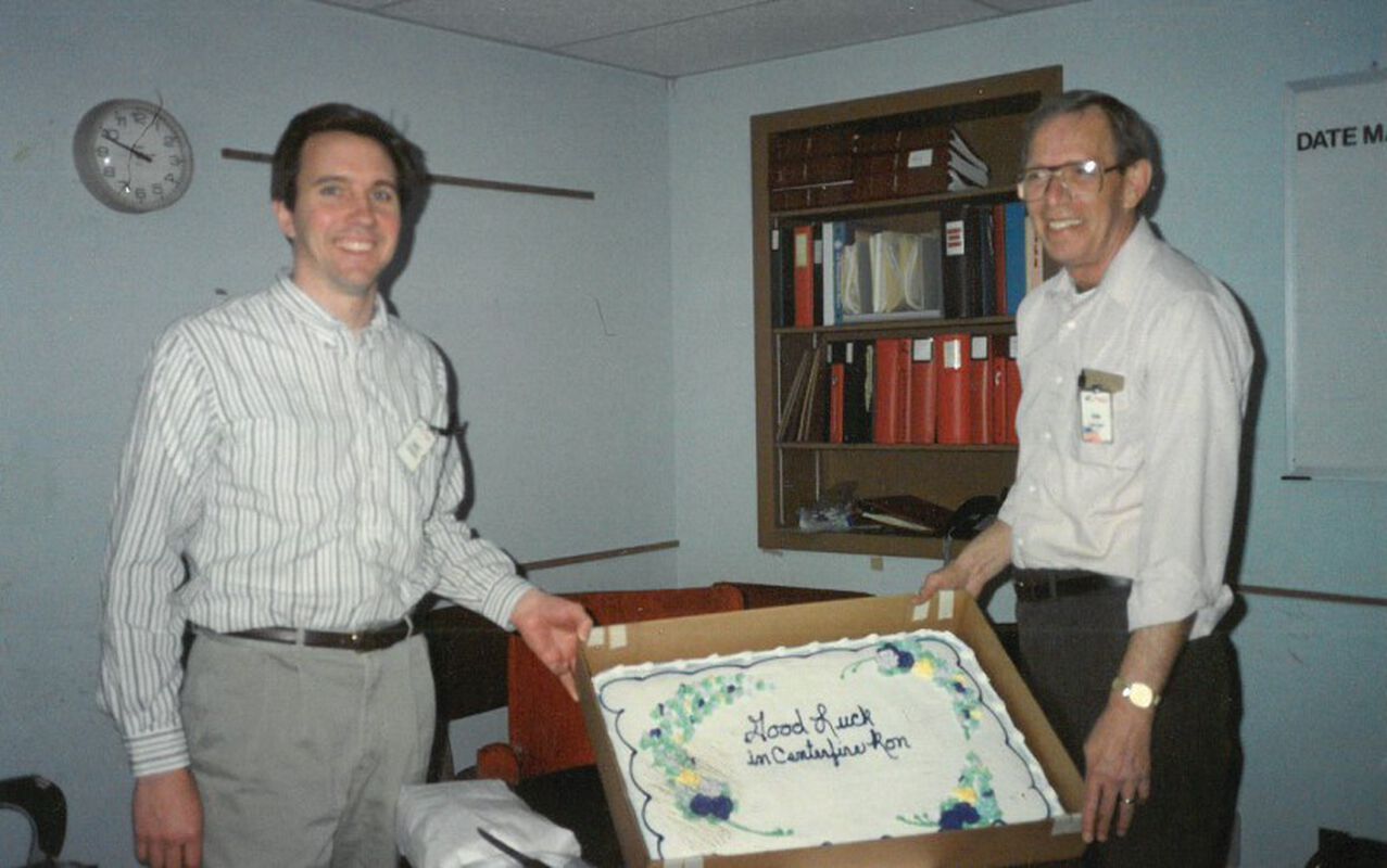 Ron Collier standing by a cake