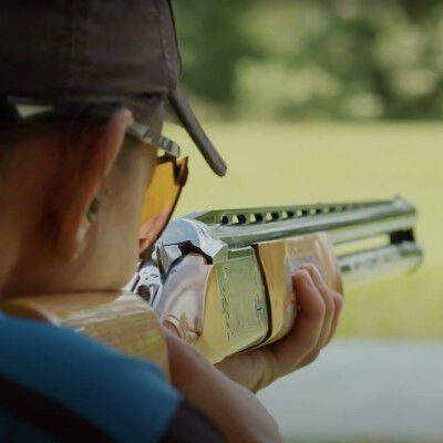 Kayle Browning looking down the iron sights of a shotgun