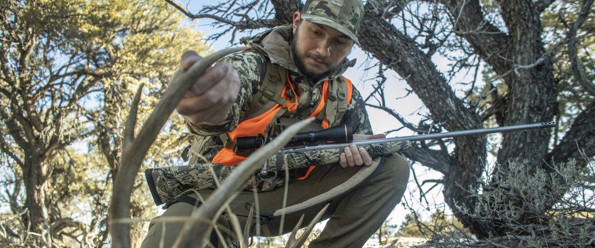 Hunter looking at a deer horn on the ground