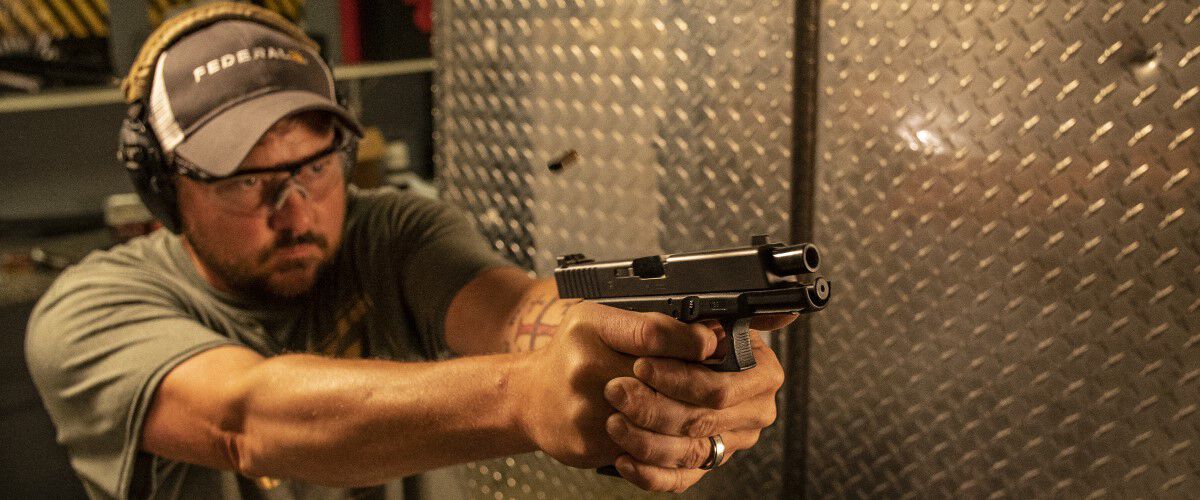 Man shooting a handgun at an indoor range