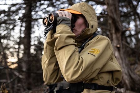 female wearing the De Havilland Jacket and looking through binoculars