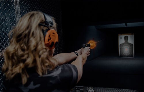 Lady shooting handgun at an indoor range