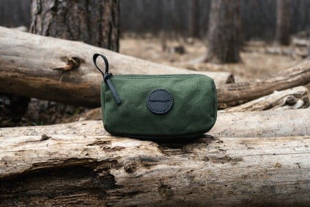 Olive Drab Grab-N-Go Bag sitting on a fallen tree trunk