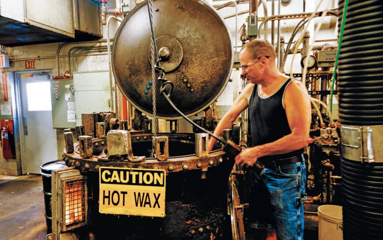 Worker at the hot wax basket