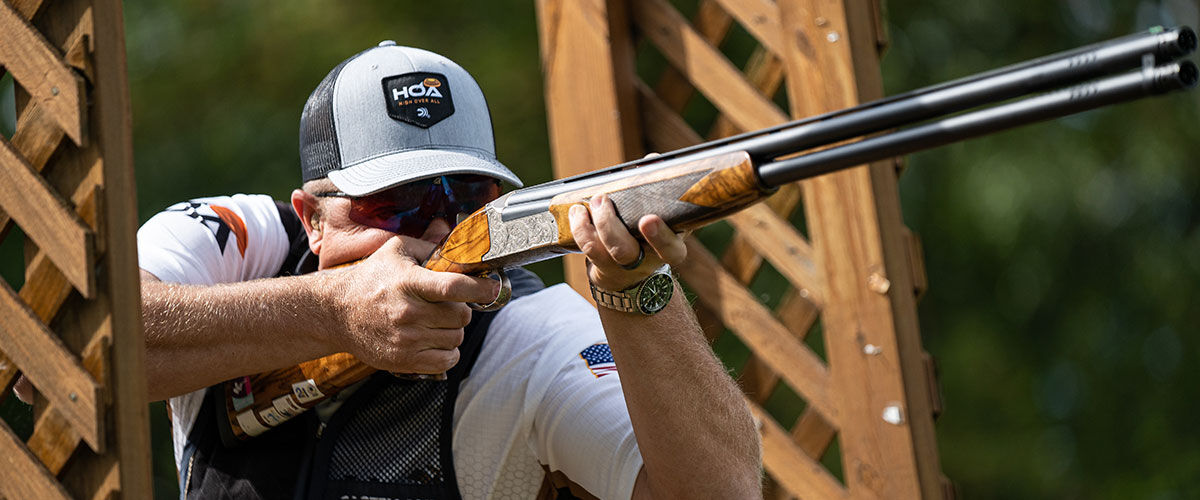 Derrick Mein aiming a shotgun